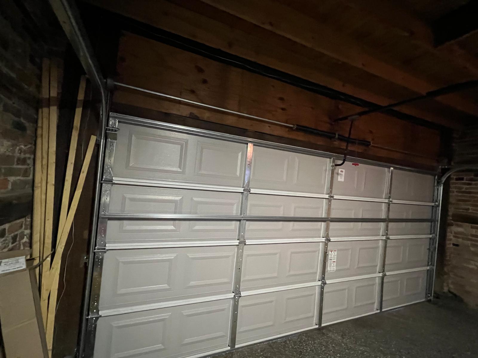 Interior angled view showing garage door panels, tracks, and framing
