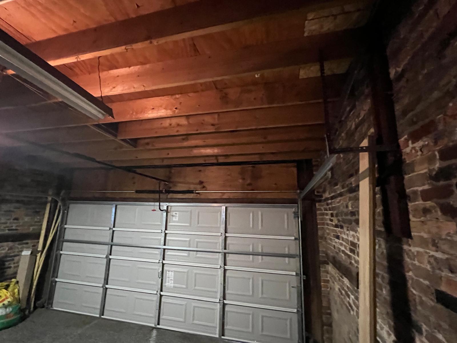 Wide interior view of the raised-panel garage door inside a brick garage
