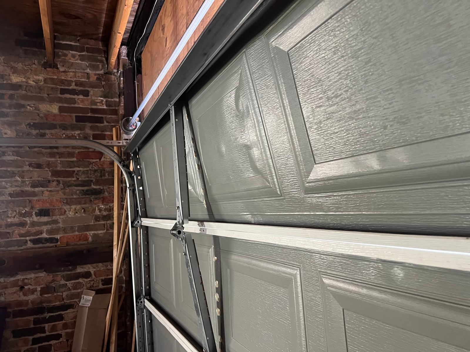Close-up of the garage door roller, hinge, and guide track